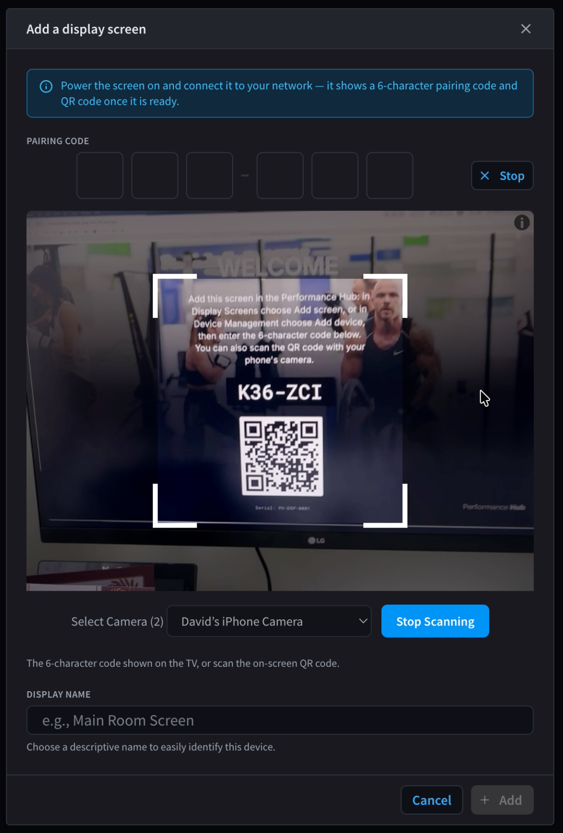 A phone scanning the QR code shown on the TV to pair the screen