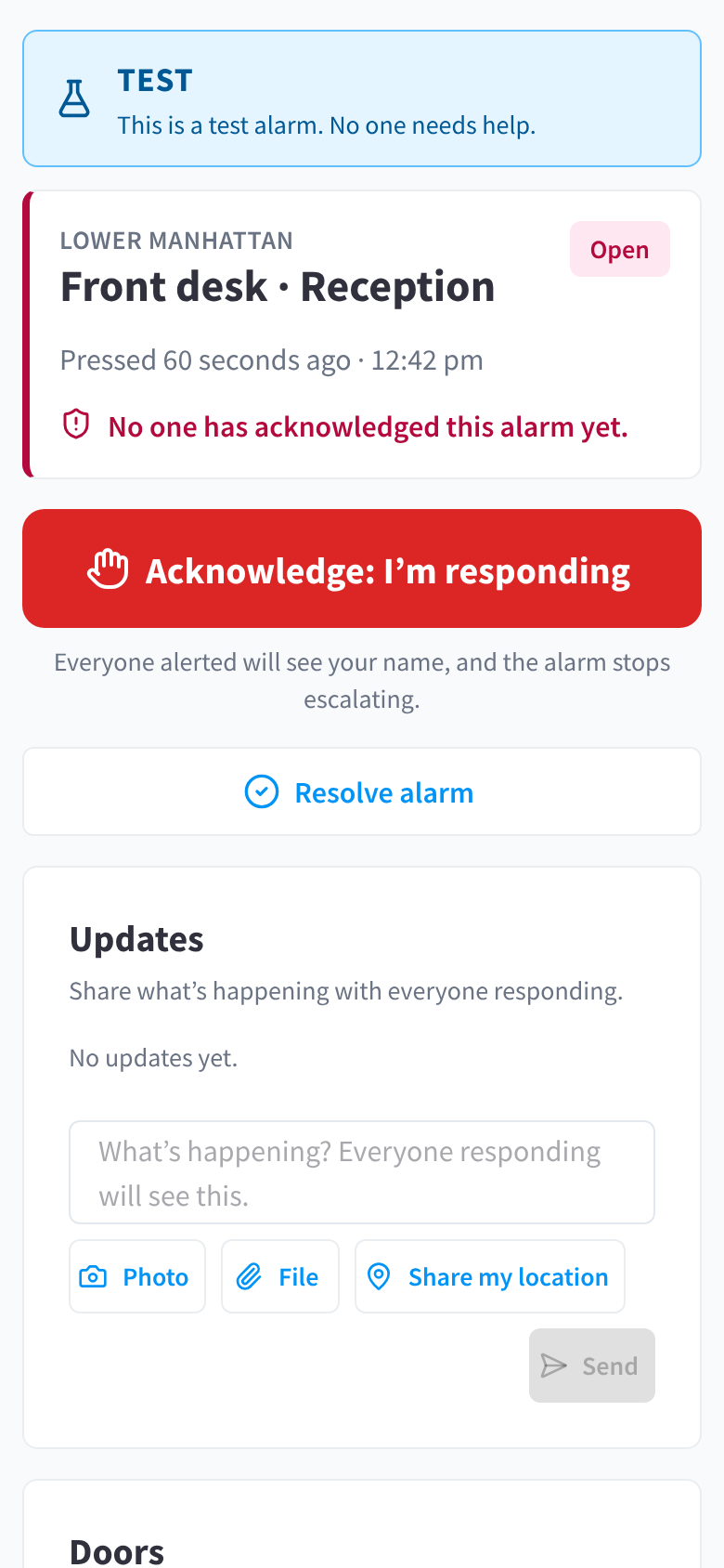A test alarm on the alarm page, with the TEST marker and the message that no one needs help, and a note that doors can't be unlocked from a test alarm